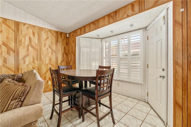 22533 Kinross Ln, Moreno Valley, CA 92557 - dining space featuring a textured ceiling, light tile patterned floors, wooden walls, and vaulted ceiling
