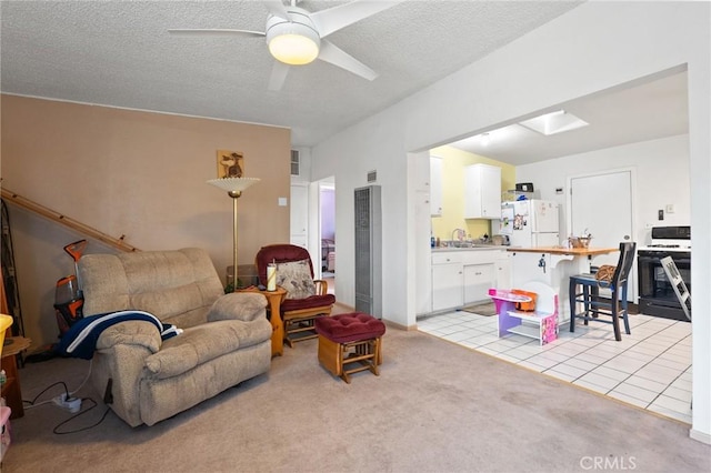 6186 Abronia Ave Unit 29, Palms, CA 92277 - living room featuring a heating unit, light carpet, ceiling fan, light tile patterned flooring, and a textured ceiling