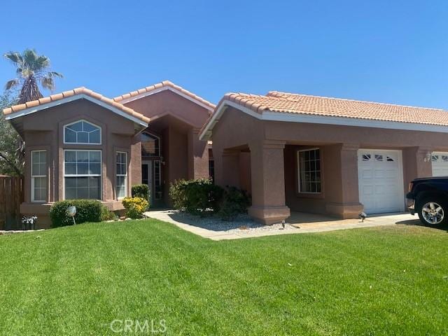 14310 Northstar Ave, Victorville, CA 92392 - ranch-style house with a tile roof, a front yard, stucco siding, and an attached garage