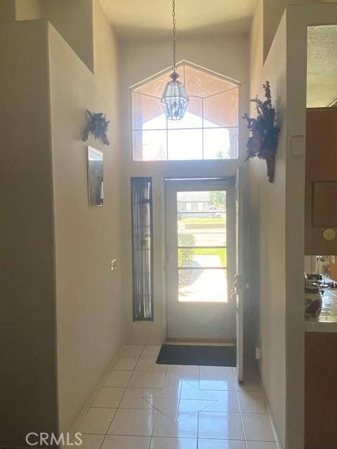 14310 Northstar Ave, Victorville, CA 92392 - foyer entrance with plenty of natural light, a chandelier, a high ceiling, and light tile patterned floors