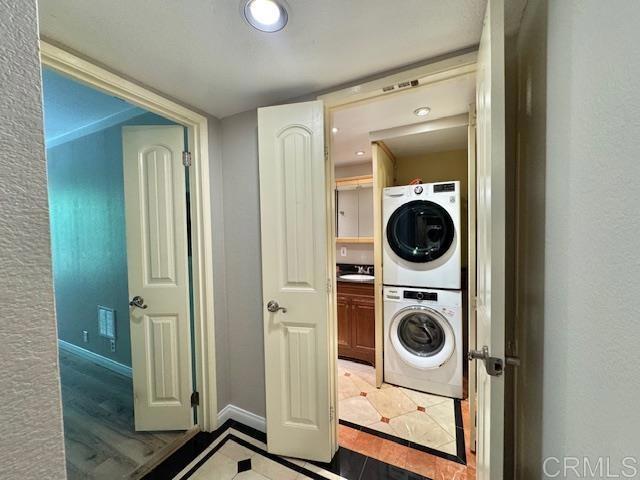 4545 Arizona St Unit 104, San Diego, CA 92116 - laundry area featuring stacked washing machine and dryer and inlaid floor details