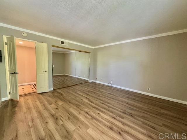 4545 Arizona St Unit 104, San Diego, CA 92116 - empty room with wood finished floors, ornamental molding, a textured ceiling, and a smoke detector