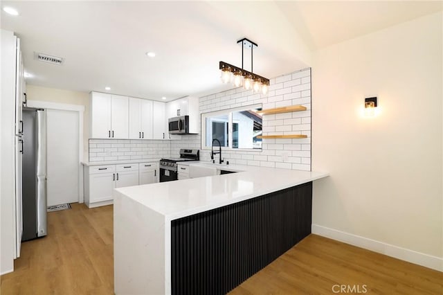 17532 Ludlow St, Granada Hills, CA 91344 - kitchen featuring stainless steel appliances, a peninsula, backsplash, light wood-style floors, and recessed lighting