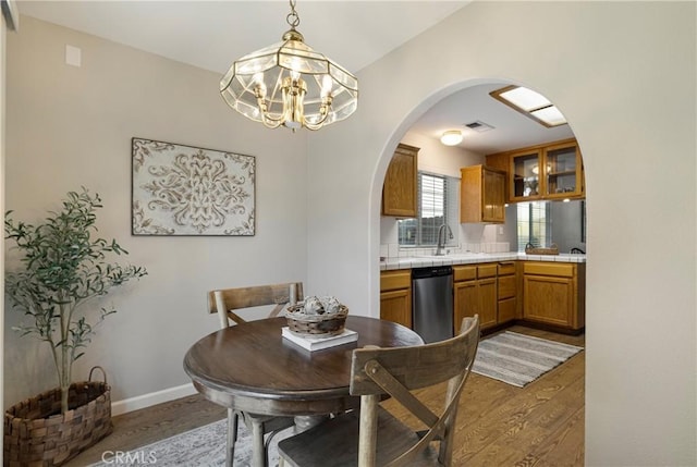 2081 Marilyn Dr, Chico, CA 95928 - dining space with arched walkways, light wood-style flooring, and a chandelier