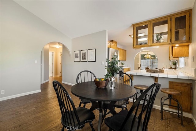 2081 Marilyn Dr, Chico, CA 95928 - dining area with arched walkways, vaulted ceiling, and dark wood-type flooring