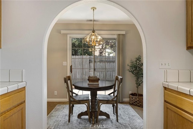 2081 Marilyn Dr, Chico, CA 95928 - dining room with arched walkways, a chandelier, and light wood-type flooring