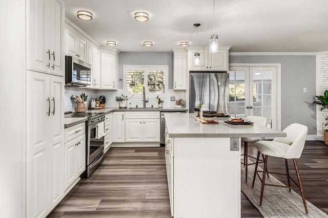 1670 Alta Vista Dr, Vista, CA 92084 - kitchen with appliances with stainless steel finishes, a kitchen breakfast bar, a kitchen island, decorative backsplash, and dark wood-type flooring