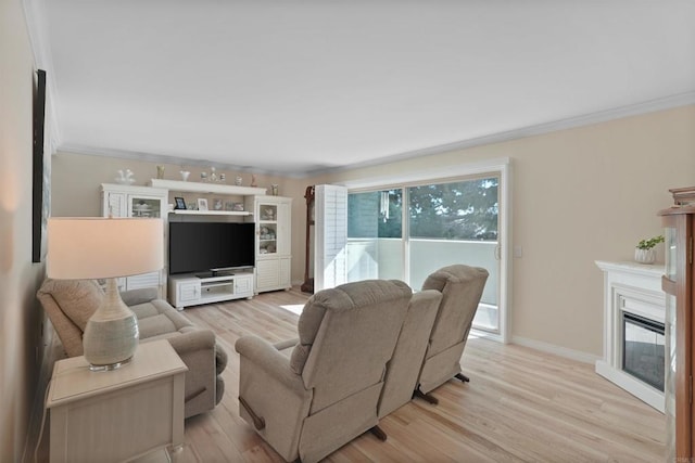 8566 Van Ness Ct Unit 19G, Huntington Beach, CA 92646 - living area with crown molding, light wood-style flooring, and a glass covered fireplace