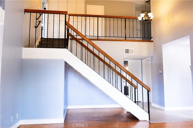 3223 Algonquin Ln, Riverside, CA 92503 - stairway featuring wood finished floors, a chandelier, and a towering ceiling
