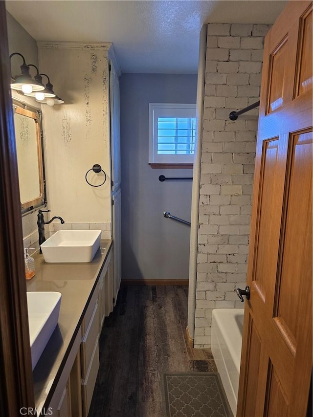 41653 62nd St W, Palmdale, CA 93551 - bathroom featuring wood finished floors, double vanity, washtub / shower combination, and a textured ceiling