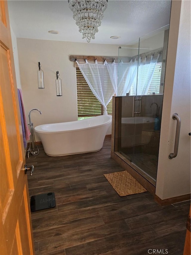 41653 62nd St W, Palmdale, CA 93551 - full bathroom featuring wood finished floors, a shower stall, a soaking tub, and a chandelier