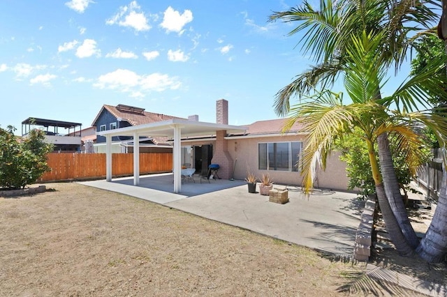 7549 Goode St, San Diego, CA 92139 - rear view of house featuring a patio, stucco siding, and a chimney
