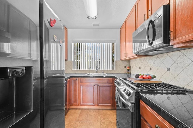 7549 Goode St, San Diego, CA 92139 - kitchen with appliances with stainless steel finishes, dark countertops, decorative backsplash, and brown cabinetry