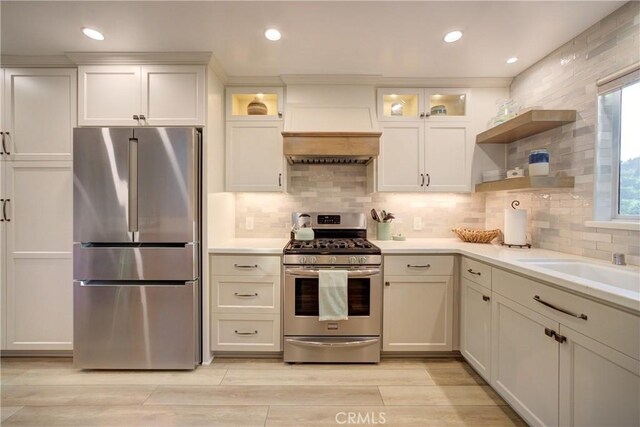 6362 Coffeeberry Ct, Avila Beach, CA 93424 - kitchen with stainless steel appliances, open shelves, premium range hood, light countertops, and light wood-type flooring