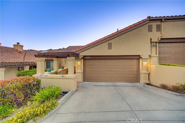 6362 Coffeeberry Ct, Avila Beach, CA 93424 - mediterranean / spanish house featuring driveway, stucco siding, a garage, and a tiled roof