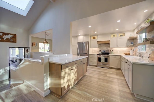6362 Coffeeberry Ct, Avila Beach, CA 93424 - kitchen featuring stainless steel appliances, a skylight, light wood finished floors, high vaulted ceiling, and light countertops