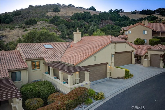 6362 Coffeeberry Ct, Avila Beach, CA 93424 - view of front of home with a tiled roof, a chimney, concrete driveway, stucco siding, and a garage