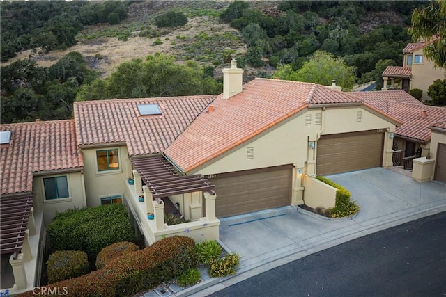 6362 Coffeeberry Ct, Avila Beach, CA 93424 - mediterranean / spanish-style home featuring driveway, stucco siding, a chimney, and an attached garage