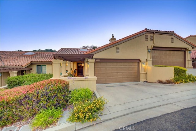 6362 Coffeeberry Ct, Avila Beach, CA 93424 - mediterranean / spanish home featuring stucco siding, an attached garage, driveway, a chimney, and a tiled roof