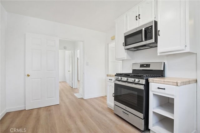 5609 Clark Ave, Lakewood, CA 90712 - kitchen with stainless steel appliances, light wood finished floors, white cabinetry, and tile counters