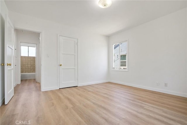 5609 Clark Ave, Lakewood, CA 90712 - unfurnished bedroom featuring multiple windows, light wood-type flooring, and attic access