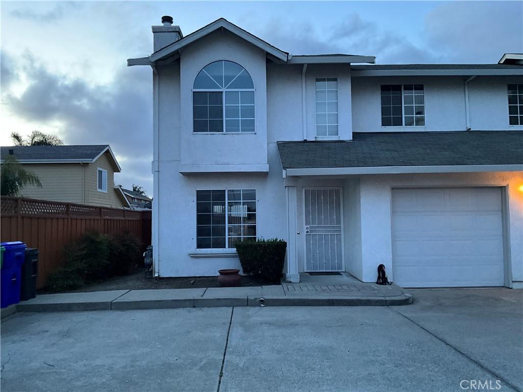 550 Blossom Way # G, Hayward, CA 94541 - traditional-style house with stucco siding, concrete driveway, a chimney, and an attached garage