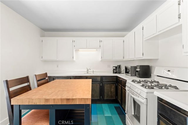 976 N Loma Vista Dr, Long Beach, CA 90813 - kitchen with white range with gas stovetop, light countertops, white cabinets, and stainless steel microwave