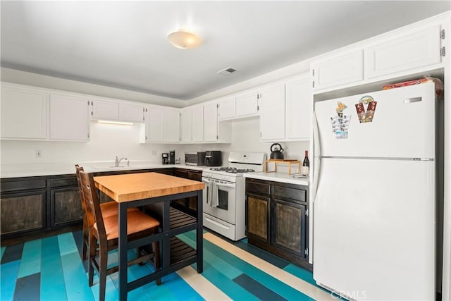 976 N Loma Vista Dr, Long Beach, CA 90813 - kitchen with white appliances, tile patterned floors, light countertops, and white cabinets