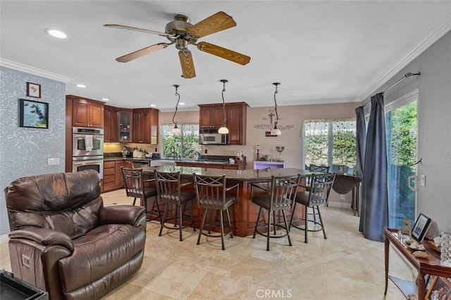 24682 Via Tequila, Lake Forest, CA 92630 - kitchen featuring appliances with stainless steel finishes, crown molding, dark countertops, a kitchen breakfast bar, and a center island