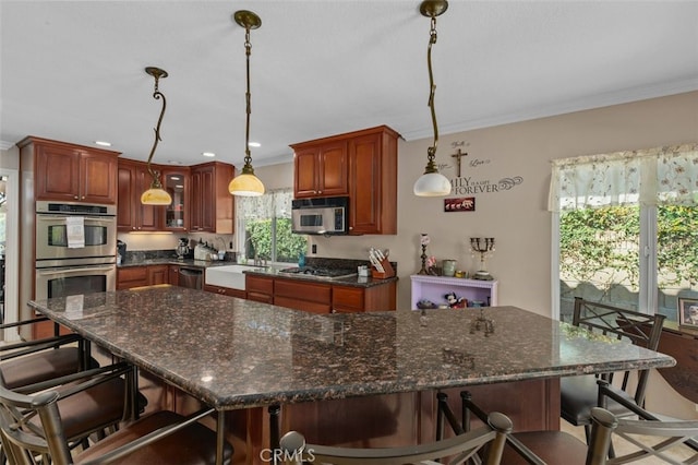 24682 Via Tequila, Lake Forest, CA 92630 - kitchen featuring stainless steel appliances, ornamental molding, a kitchen bar, a spacious island, and glass insert cabinets