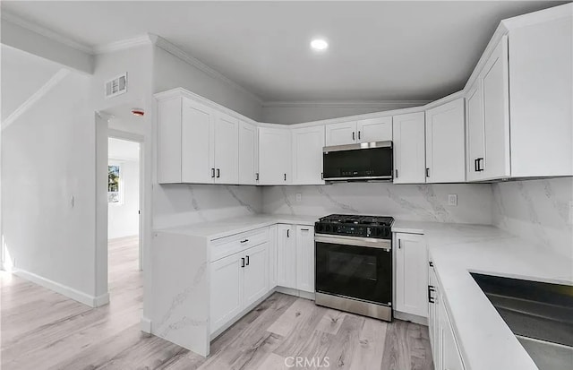 11912 Arthur Dr, Anaheim, CA 92804 - kitchen featuring stainless steel microwave, gas range oven, white cabinets, light wood-style flooring, and ornamental molding