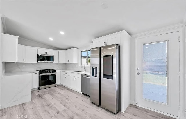 11912 Arthur Dr, Anaheim, CA 92804 - kitchen with appliances with stainless steel finishes, light countertops, white cabinetry, backsplash, and lofted ceiling