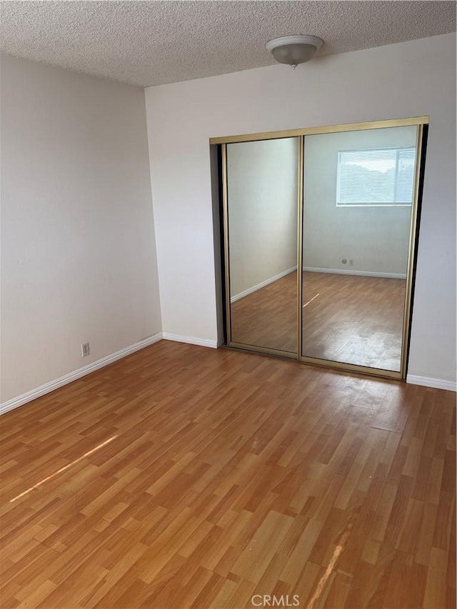 2501 W Redondo Beach Blvd Unit 317, Gardena, CA 90249 - unfurnished bedroom featuring light wood-style flooring, a closet, and a textured ceiling