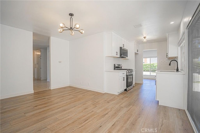 20157 Mckay Dr, Walnut, CA 91789 - kitchen featuring appliances with stainless steel finishes, light countertops, light wood-style flooring, a chandelier, and white cabinets