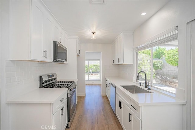 20157 Mckay Dr, Walnut, CA 91789 - kitchen featuring appliances with stainless steel finishes, light wood-type flooring, backsplash, white cabinets, and recessed lighting