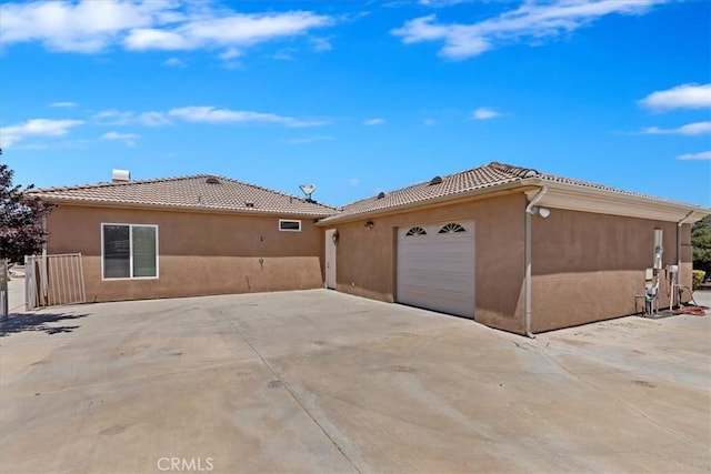 22515 Santa Clarita Corte, Perris, CA 92570 - view of side of home with a tile roof, stucco siding, concrete driveway, and a garage