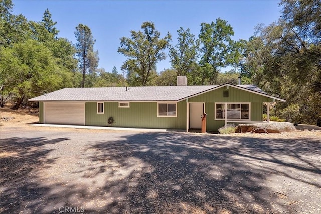 5566 Darrah Rd, Mariposa, CA 95338 - view of front of property with gravel driveway, a chimney, a garage, and view of wooded area