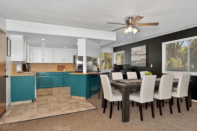 5566 Darrah Rd, Mariposa, CA 95338 - dining area with healthy amount of natural light, a ceiling fan, a textured ceiling, wood walls, and light colored carpet