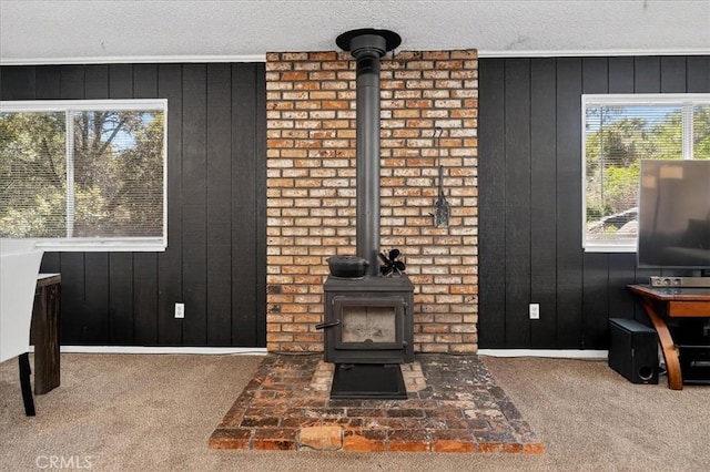 5566 Darrah Rd, Mariposa, CA 95338 - living area featuring a wood stove, carpet, healthy amount of natural light, wooden walls, and a textured ceiling