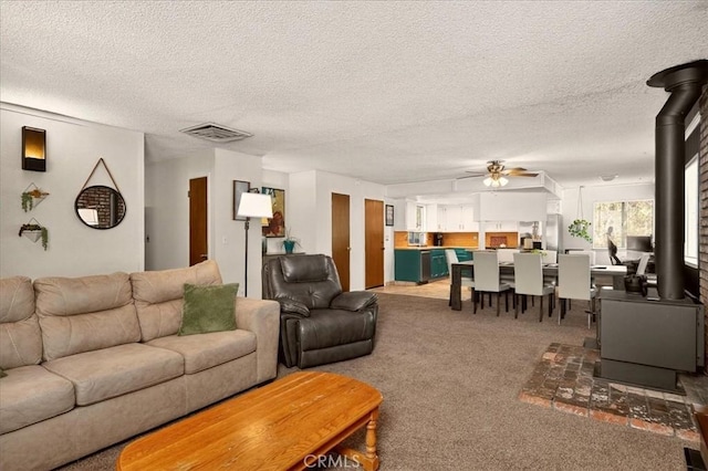 5566 Darrah Rd, Mariposa, CA 95338 - living area with a wood stove, a ceiling fan, a textured ceiling, and carpet floors