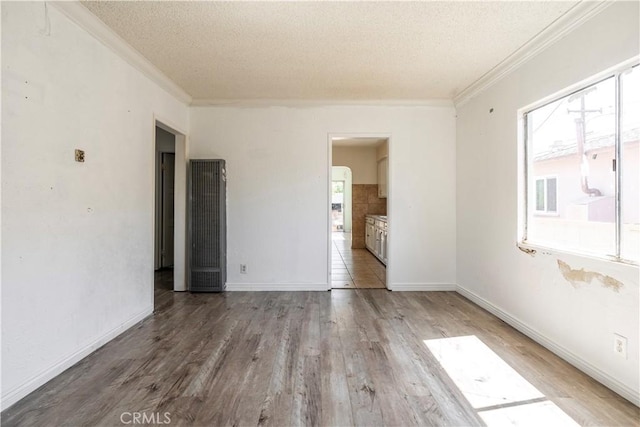 4576 166th St, Lawndale, CA 90260 - empty room with a textured ceiling, plenty of natural light, ornamental molding, wood finished floors, and a heating unit