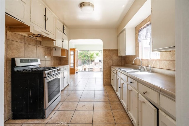 4576 166th St, Lawndale, CA 90260 - kitchen featuring stainless steel range with gas stovetop, light countertops, light tile patterned floors, white cabinetry, and tasteful backsplash
