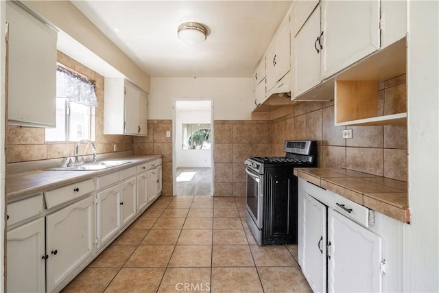 4576 166th St, Lawndale, CA 90260 - kitchen with gas stove, white cabinets, light tile patterned floors, tile walls, and backsplash