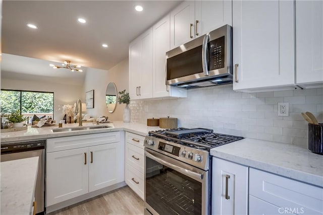 321 Orange Blossom Unit 166, Irvine, CA 92618 - kitchen featuring stainless steel appliances, white cabinetry, tasteful backsplash, light stone countertops, and recessed lighting