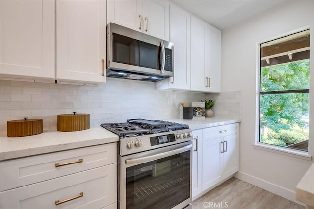 321 Orange Blossom Unit 166, Irvine, CA 92618 - kitchen with stainless steel appliances, white cabinetry, light wood finished floors, and backsplash