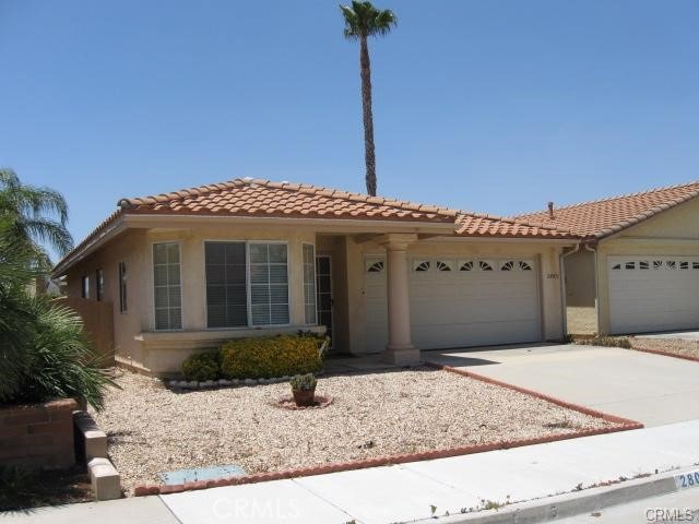 28051 Calle Casera, Menifee, CA 92585 - mediterranean / spanish-style house featuring an attached garage, a tiled roof, driveway, and stucco siding