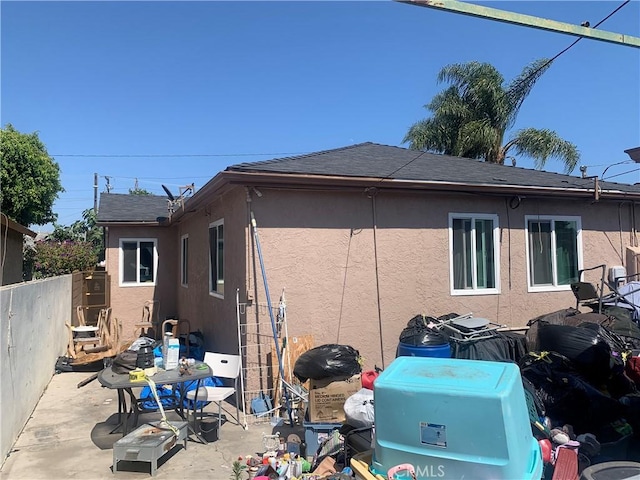 22315 Ibex Ave, Hawaiian Gardens, CA 90716 - view of side of home with stucco siding, a patio area, and roof with shingles