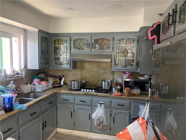 22315 Ibex Ave, Hawaiian Gardens, CA 90716 - kitchen featuring range hood, appliances with stainless steel finishes, backsplash, wood finished floors, and light countertops