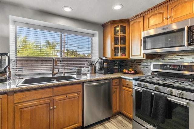817 Granite Privado, Ontario, CA 91762 - kitchen featuring appliances with stainless steel finishes, brown cabinets, backsplash, glass insert cabinets, and recessed lighting