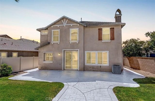43024 Beamer Ct, Temecula, CA 92592 - back of property at dusk featuring stucco siding, a fenced backyard, a chimney, and a patio area